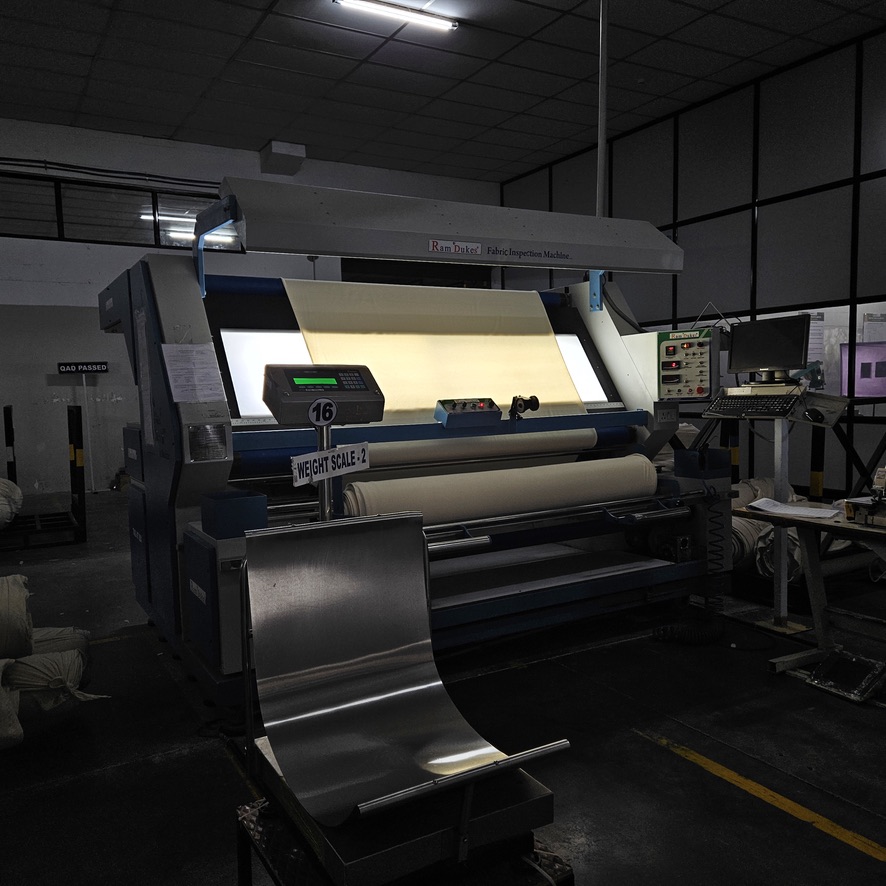 Backlit fabric inspection machine checking cloth quality