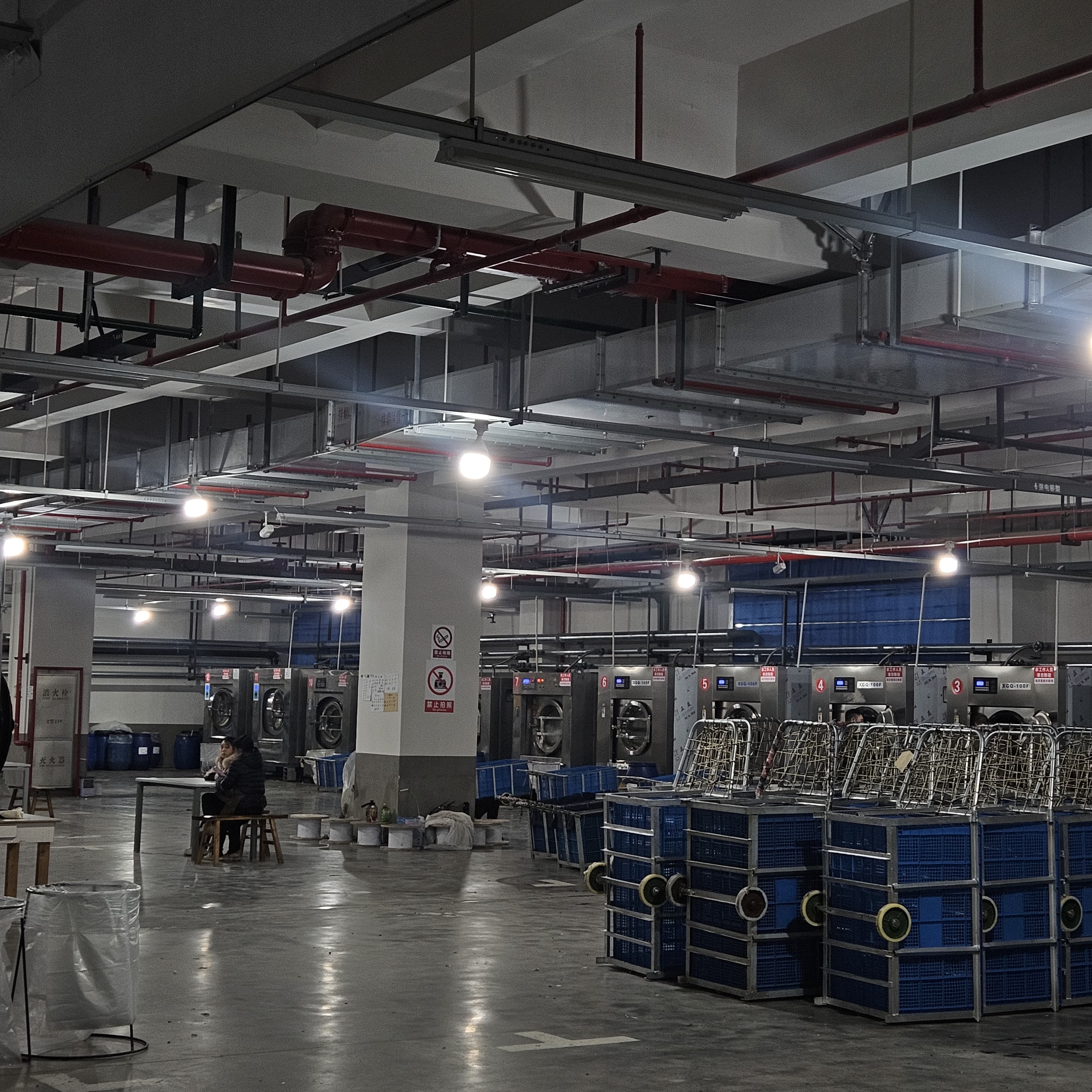 Industrial washing machines and garment carts on factory floor