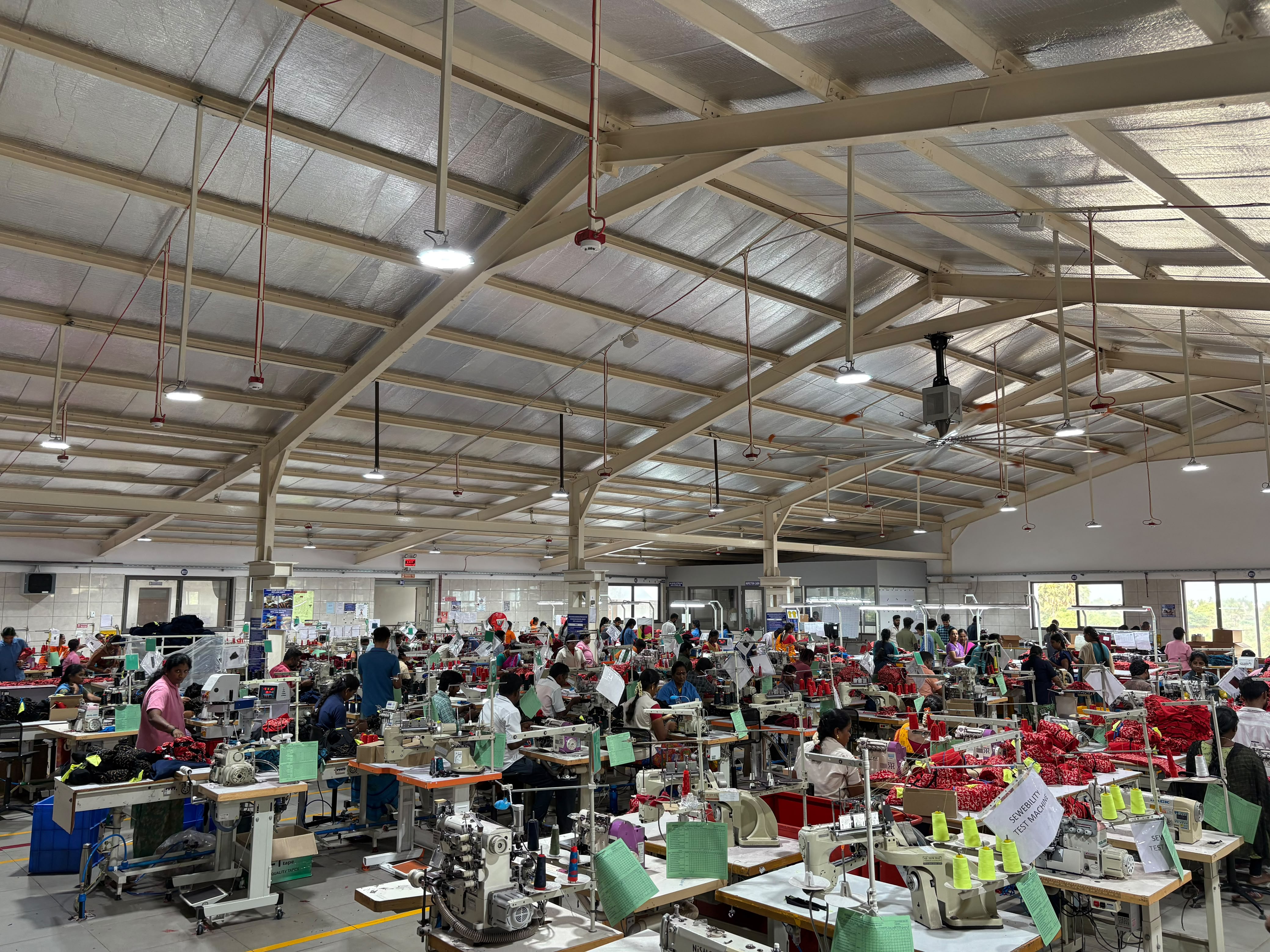 Row of sewing machines with operators stitching garments